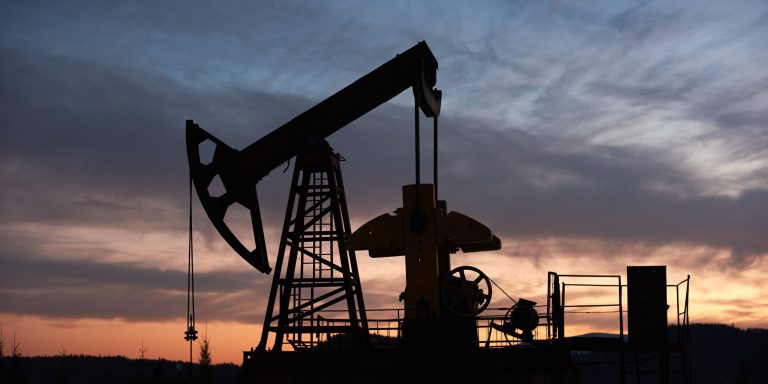 Beautiful sunset over oil field with pump jack.