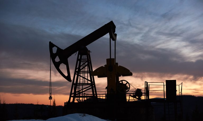 Beautiful sunset over oil field with pump jack.
